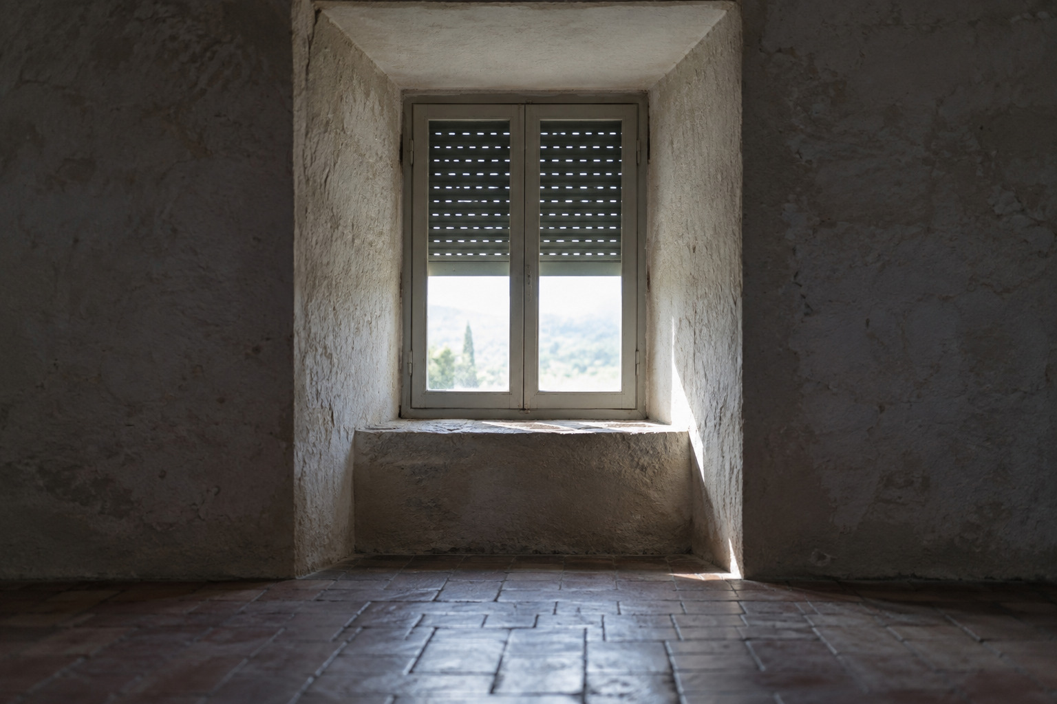 Volet roulant en position mi-ouverte vu de l'intérieur d'une maison